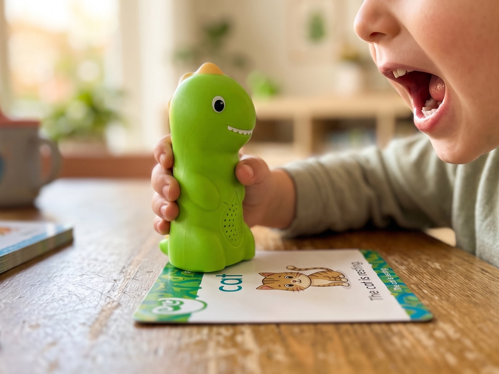 Close-up of a child saying a sound back to PhonicsBuddy on the cat flash card
